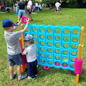 XXL-4-Gewinnt-Spiel an dem zwei Kinder spielen- zum Mieten für Firmenfeiern, Kinderfeste und Outdoor-Events – Eventmodul bei Eventvermietung