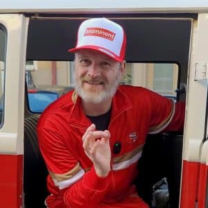 Brominent im Türrahmen: Comedy Moderator mit Mütze auf der Brominent steht im VW Oldtimer-Bus.
