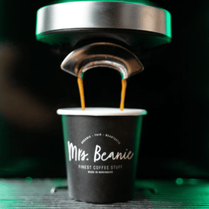 Frischer Kaffee läuft in einen edlen Mrs. Beanie Kaffebecher während der Zubereitung