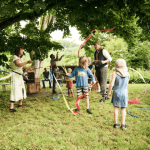Kinder, Erwachsene und der Künstler in Aktion unter freiem Himmel.