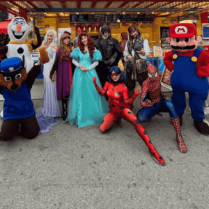 Große Gruppe von Walking Acts: Schneemann, Hunde-Helden, Spinnen-Held, Fledermaus-Mann, Prinzessinen, Piraten und Märchen-Prinzessinen.